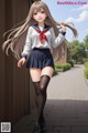 A girl in a school uniform is walking down a sidewalk.