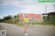 A woman standing in the middle of a parking lot.