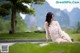 A woman in a white dress sitting on a bench.