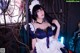A woman in a maid outfit posing for a picture.