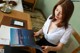 A woman sitting at a desk reading a book.