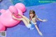 A woman laying on an inflatable flamingo in a swimming pool.